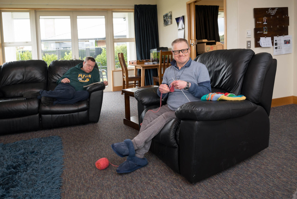 a person sitting in a chair knitting